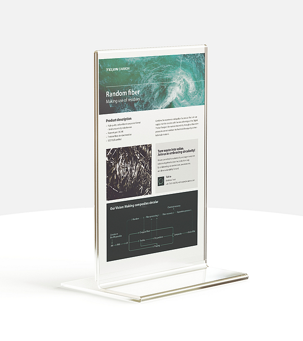 in Messedisplay von Teijin Carbon, das das Produkt "Random Fiber" bewirbt, eine hochwertige, recycelte Kohlefaser, die aus Rückständen gewonnen wird. Der Text auf dem Display beschreibt die Produktmerkmale und den Ansatz der Kreislaufwirtschaft des Unternehmens. 